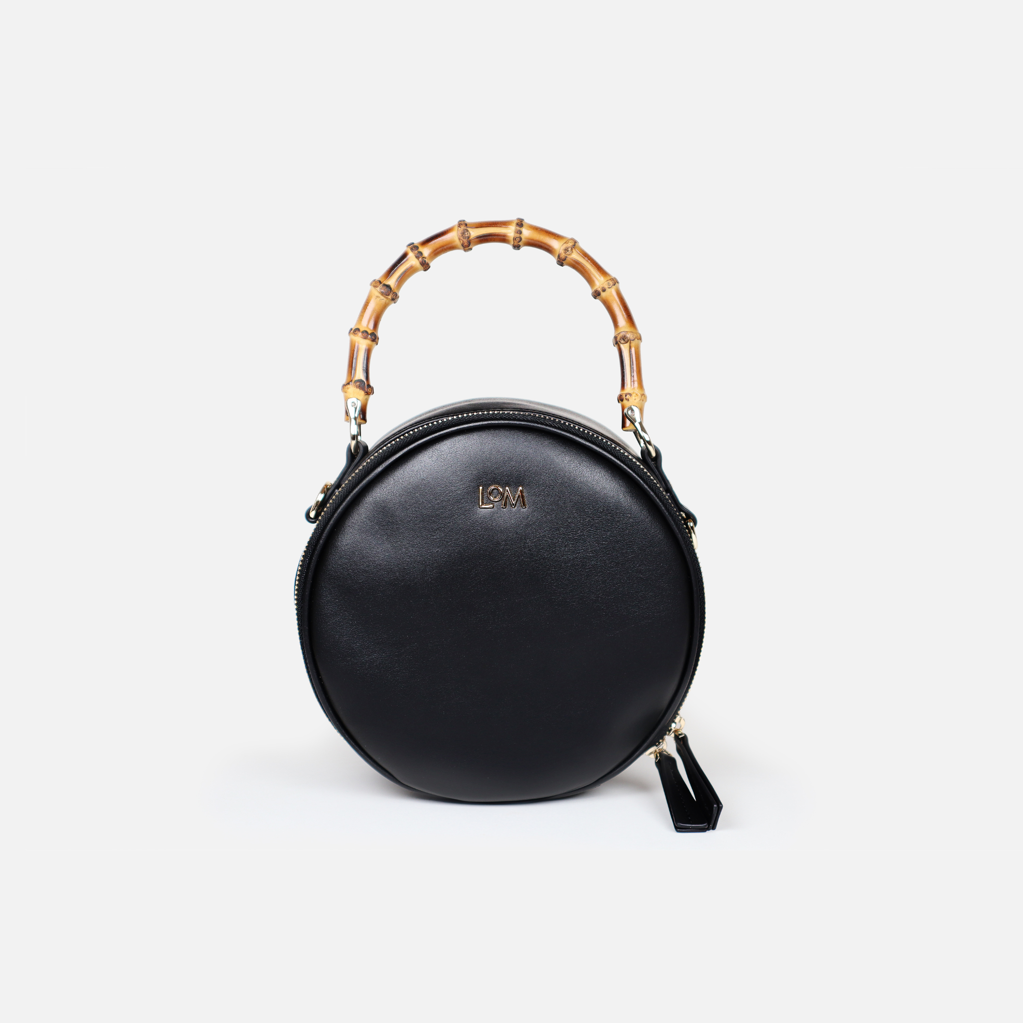 Circular handbag with bamboo handle. Made from premium black cactus leather, light gold hardware, black organic cotton lining.