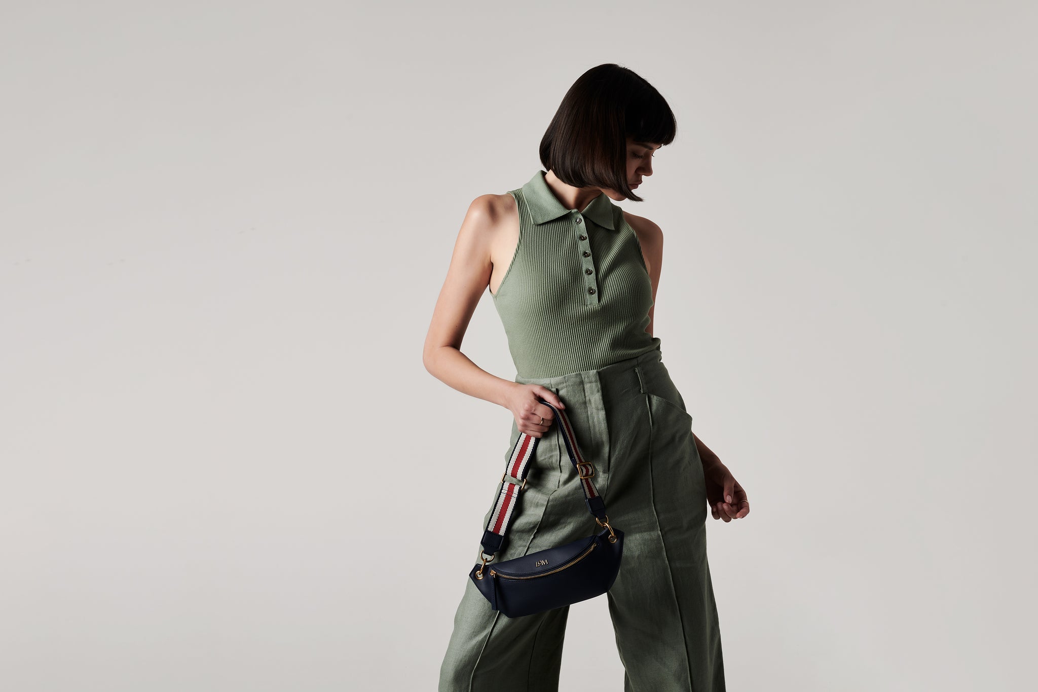 LOM Australia - model wears Stella Belt Bag in navy vegan cactus leather with Chamaeleon Red, White & Navy cotton webbing strap.