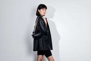 LOM Australia - Model wears Leia Belt Bag in black vegan cactus leather with Black & White cotton webbing strap. 